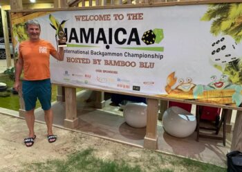 Mike Neagu poses outside Backgammon Hall with his winning trophy